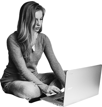 Junge Frau sitzt vor Laptop und schreibt etwas mit der Tastatur